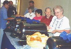 A line of people waiting for food at the buffet