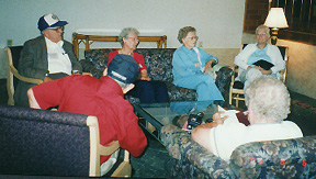 Several members share stories over a coffee table