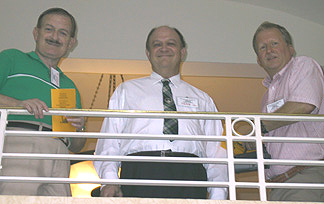Three men looking down from a railing