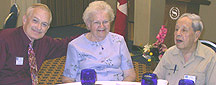 Three members posing at a table