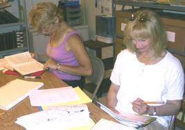 A couple of members sitting at a table looking through books