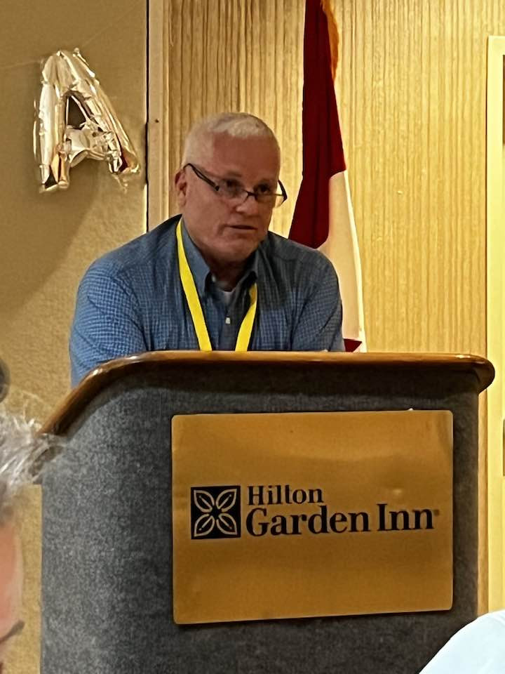 Unknown man standing in front of a podium.