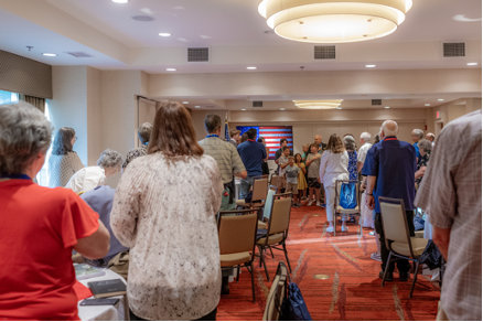 Ballroom full of people giving their respects to veterans
